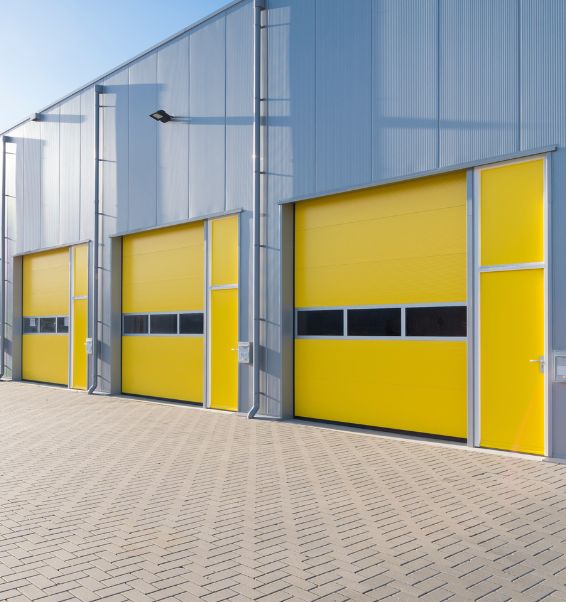 exterior of a commercial warehouse with yellow garage doors 2 lansing mi